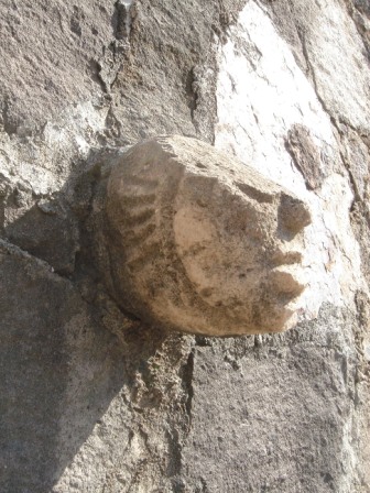 Tête sculptée prehispanique prise dans un mur du village de Teotitlan del Valle, Oaxaca, Mexique
